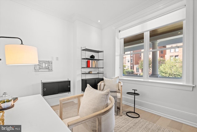 office space with wood finished floors, a healthy amount of sunlight, crown molding, and baseboards