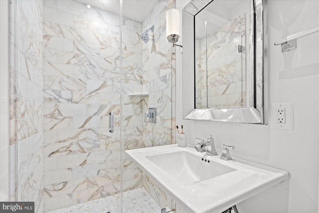 full bath featuring a sink and a marble finish shower