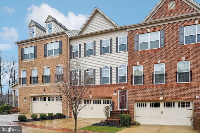 multi unit property featuring brick siding, an attached garage, and driveway