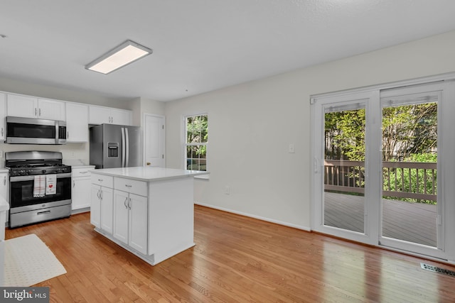 kitchen with light countertops, white cabinetry, appliances with stainless steel finishes, and light wood-style flooring