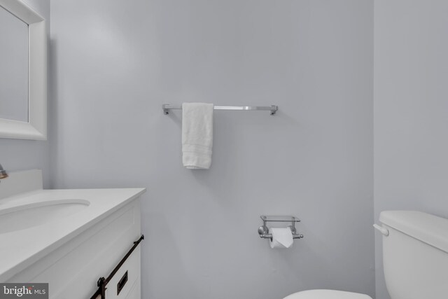 half bath featuring vanity and toilet