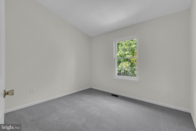 empty room featuring baseboards, carpet flooring, and visible vents
