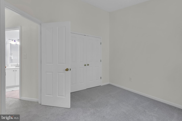 unfurnished bedroom featuring carpet floors, baseboards, and a closet