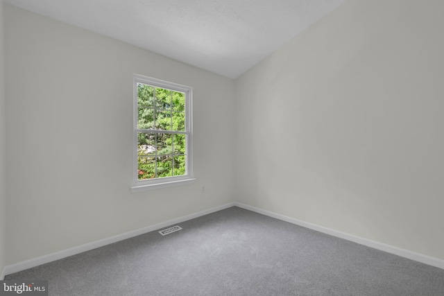 carpeted empty room featuring baseboards and visible vents