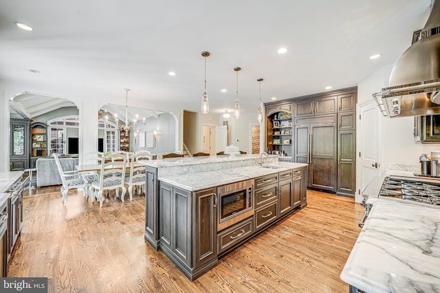 6020 Copely Ln, Mclean, VA 22101 - kitchen with island exhaust hood, arched walkways, a sink, and built in appliances