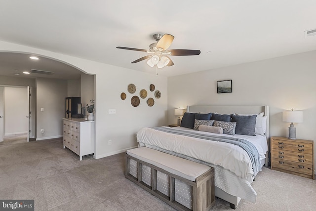 bedroom featuring visible vents, arched walkways, a ceiling fan, and carpet