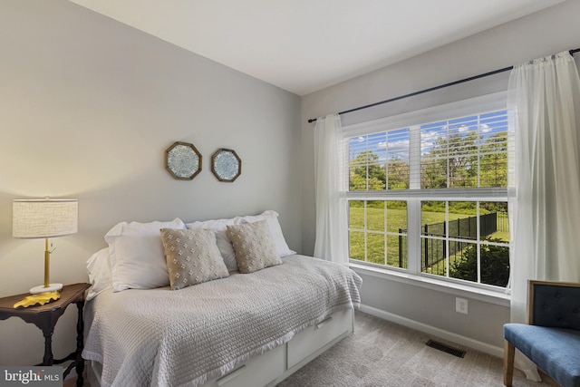 carpeted bedroom featuring visible vents and baseboards