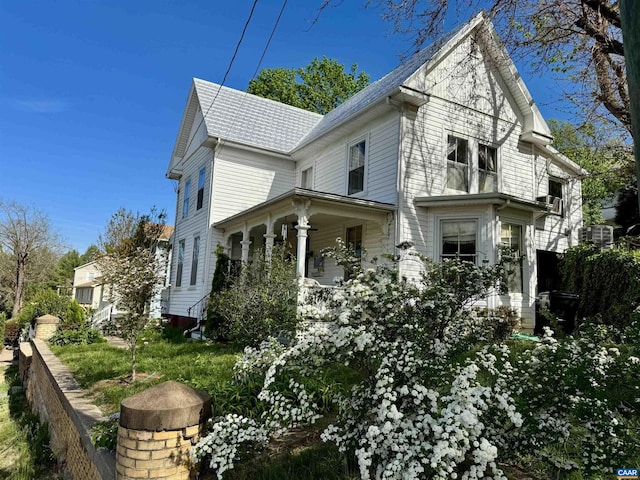 view of side of property featuring central AC and covered porch