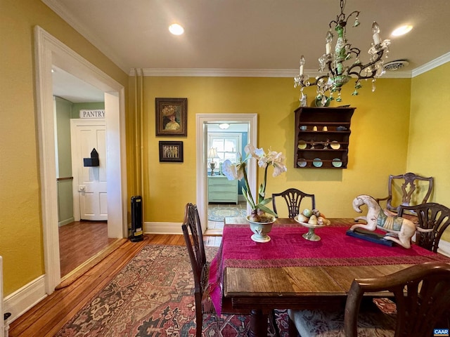 dining space with baseboards, crown molding, and wood finished floors
