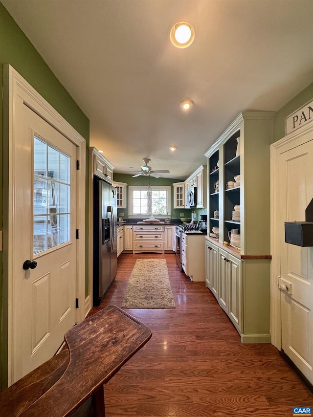 kitchen with dark wood-style flooring, dark countertops, recessed lighting, glass insert cabinets, and appliances with stainless steel finishes
