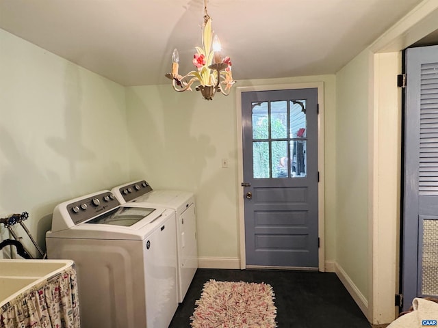 laundry room with laundry area, a sink, washing machine and clothes dryer, baseboards, and a notable chandelier
