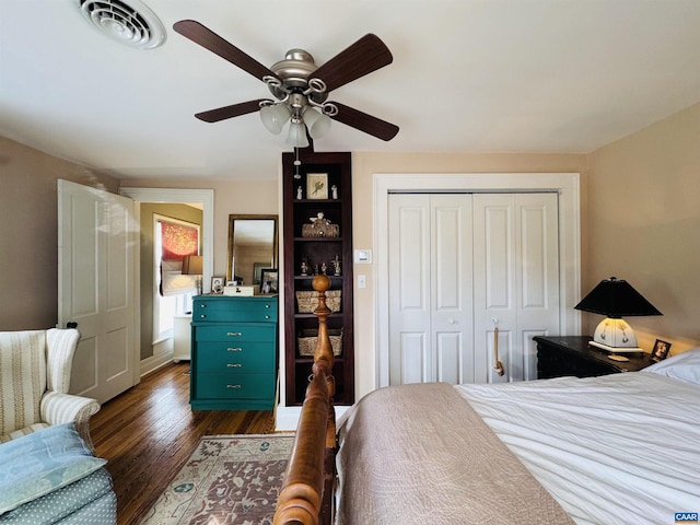 bedroom featuring a closet, ceiling fan, visible vents, baseboards, and dark wood-style floors