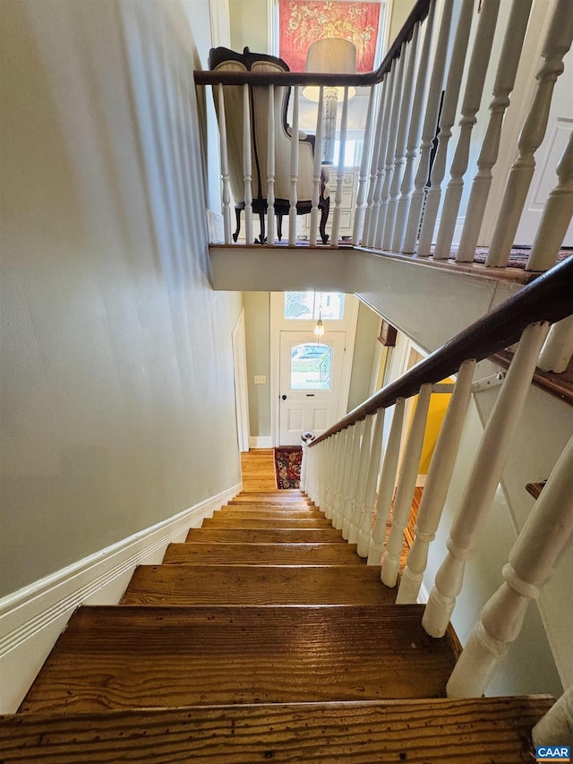 stairs with wood finished floors and baseboards
