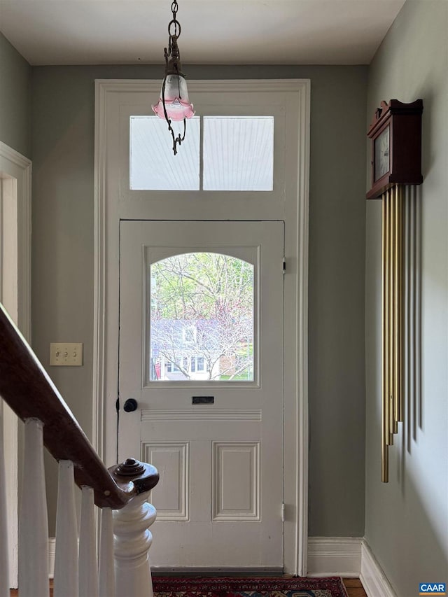 foyer entrance with baseboards and stairs