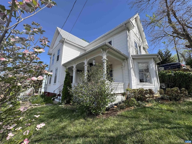 view of home's exterior featuring a lawn, a porch, and a ceiling fan