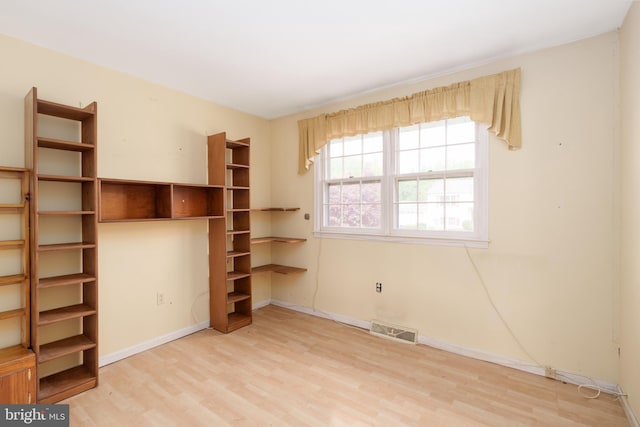 unfurnished bedroom featuring visible vents, wood finished floors, and baseboards