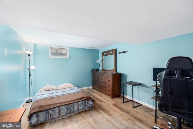 bedroom with baseboards and wood finished floors