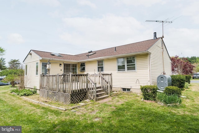 back of house featuring heating fuel, a wooden deck, and a yard