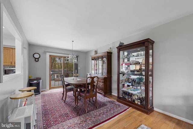 2411 Nickoles Dr, Sykesville, MD 21784 - dining space with wood finished floors, baseboards, and an inviting chandelier