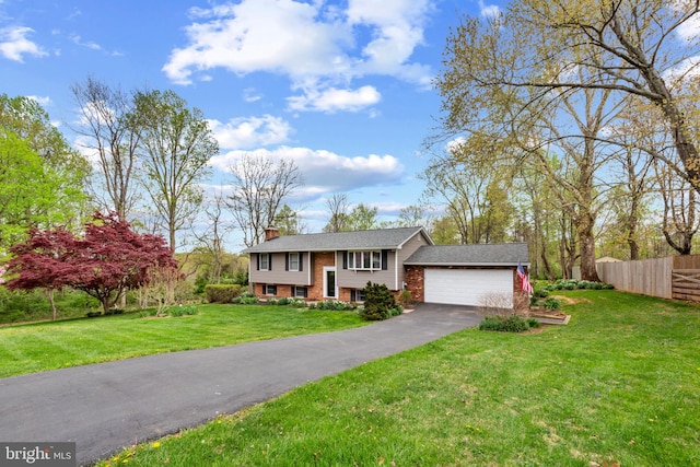 2411 Nickoles Dr, Sykesville, MD 21784 - bi-level home with a chimney, fence, an attached garage, driveway, and brick siding