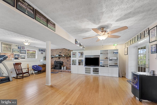 2411 Nickoles Dr, Sykesville, MD 21784 - living area with wood finished floors, a wood stove, a textured ceiling, and ceiling fan