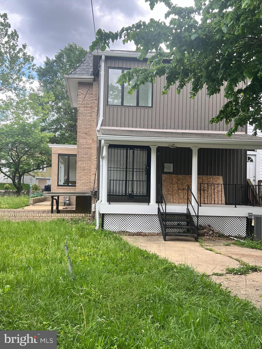 back of property featuring board and batten siding and covered porch