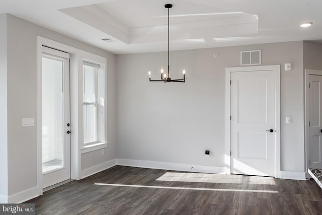 unfurnished dining area featuring visible vents, baseboards, dark wood-type flooring, and a chandelier