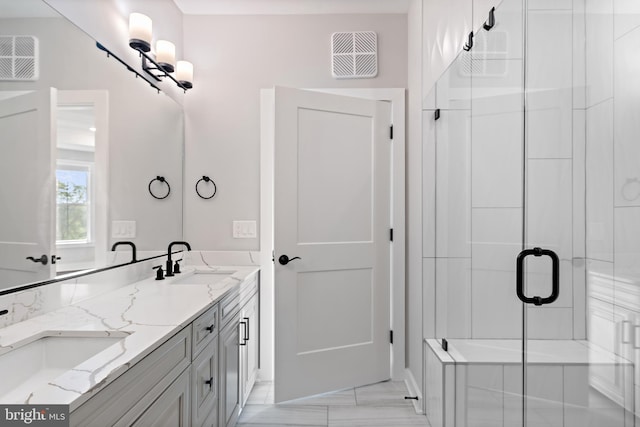 bathroom with visible vents, a sink, and a shower stall