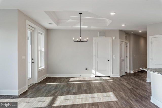 unfurnished dining area featuring baseboards, a chandelier, a raised ceiling, and dark wood-type flooring