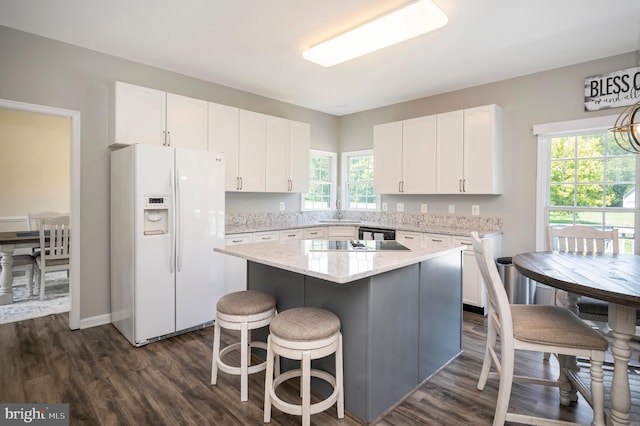 kitchen with dark wood-style flooring, a center island, plenty of natural light, white fridge with ice dispenser, and white cabinetry