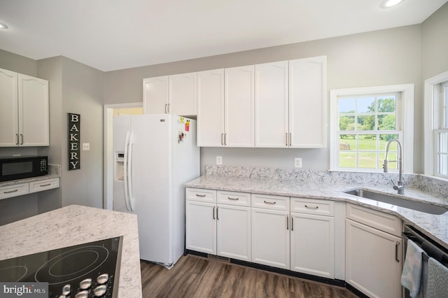kitchen featuring black appliances, white cabinetry, a sink, and dark wood-type flooring