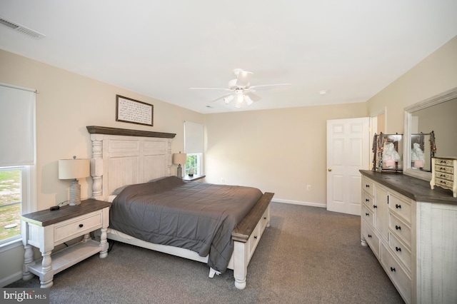 bedroom with dark carpet, ceiling fan, baseboards, and visible vents