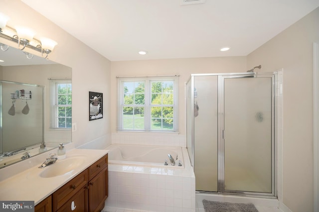 bathroom with recessed lighting, a bath, a shower stall, and vanity