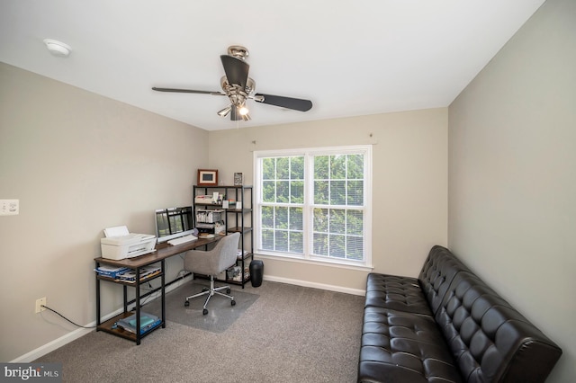 carpeted office featuring a ceiling fan and baseboards