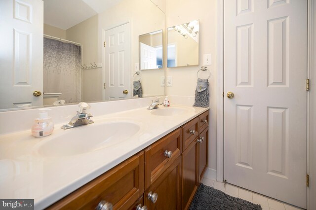 full bathroom featuring tile patterned floors, a sink, and double vanity