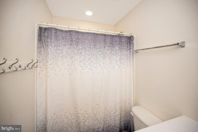 bathroom with toilet and a shower with curtain