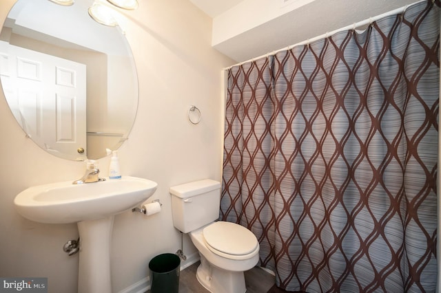 full bath featuring toilet and baseboards