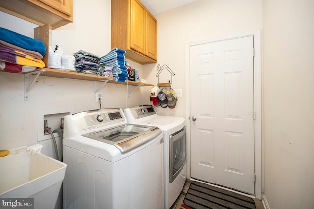laundry room featuring cabinet space, washing machine and clothes dryer, and a sink