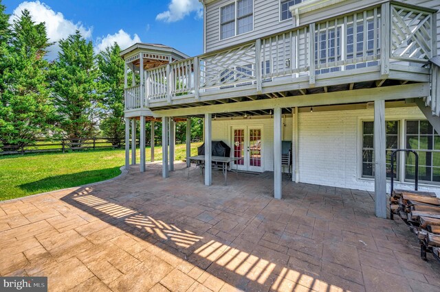 view of patio with french doors, fence, and a deck