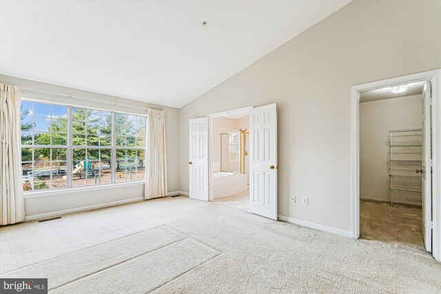 unfurnished bedroom with visible vents, vaulted ceiling, carpet, and baseboards
