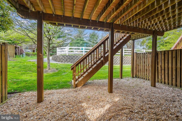 view of patio featuring stairway and fence