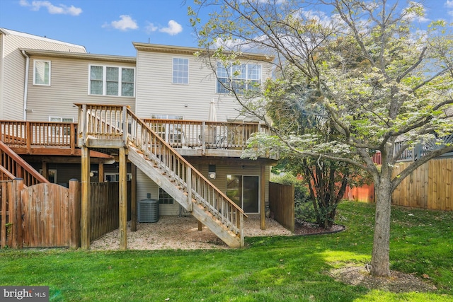 back of house with a deck, a lawn, stairs, and central AC