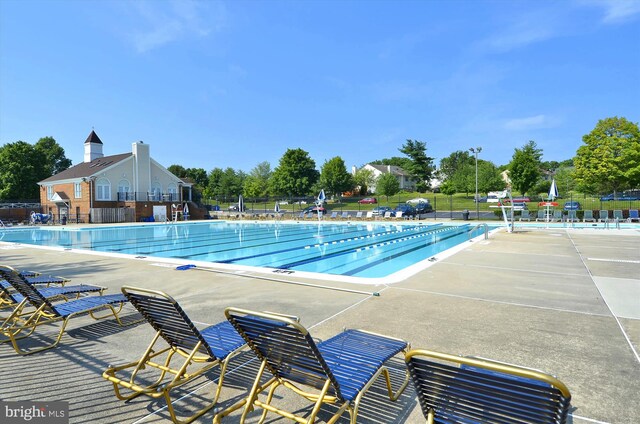 community pool with a patio and fence