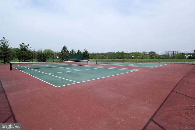 view of tennis court featuring fence and community basketball court