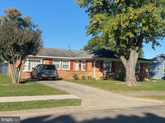 ranch-style house with driveway, a front yard, and brick siding