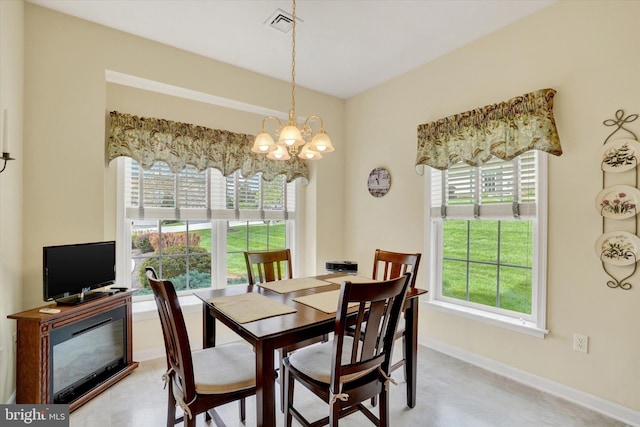 dining space with baseboards, visible vents, and a chandelier