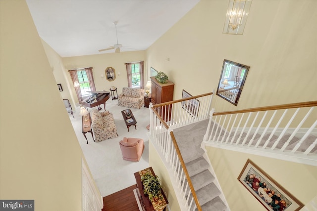 stairway featuring ceiling fan and high vaulted ceiling