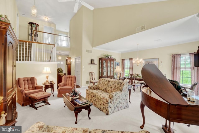 living area featuring plenty of natural light, light carpet, a high ceiling, and visible vents