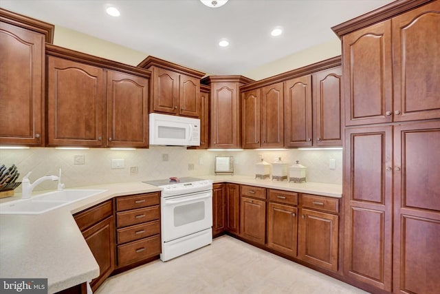kitchen with white appliances, light countertops, a sink, and tasteful backsplash