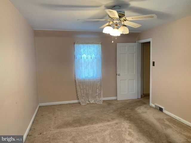 unfurnished room featuring a ceiling fan, carpet flooring, and baseboards